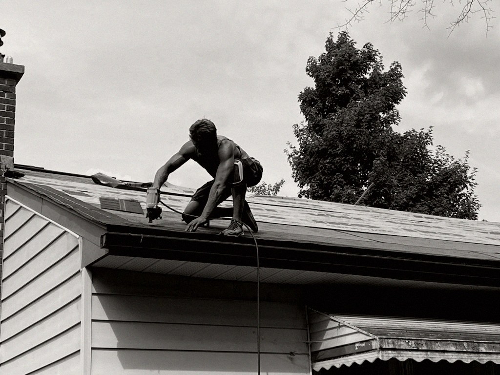 Josh Pearsall working on a roof in Ottawa, with a nail gun.